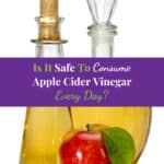 Apple cider vinegar in a glass vessel and red apple.