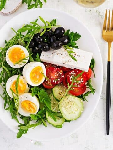 Breakfast. Greek salad and boiled eggs. Fresh vegetable salad with tomato, cucumbers, olives, arugula and feta cheese