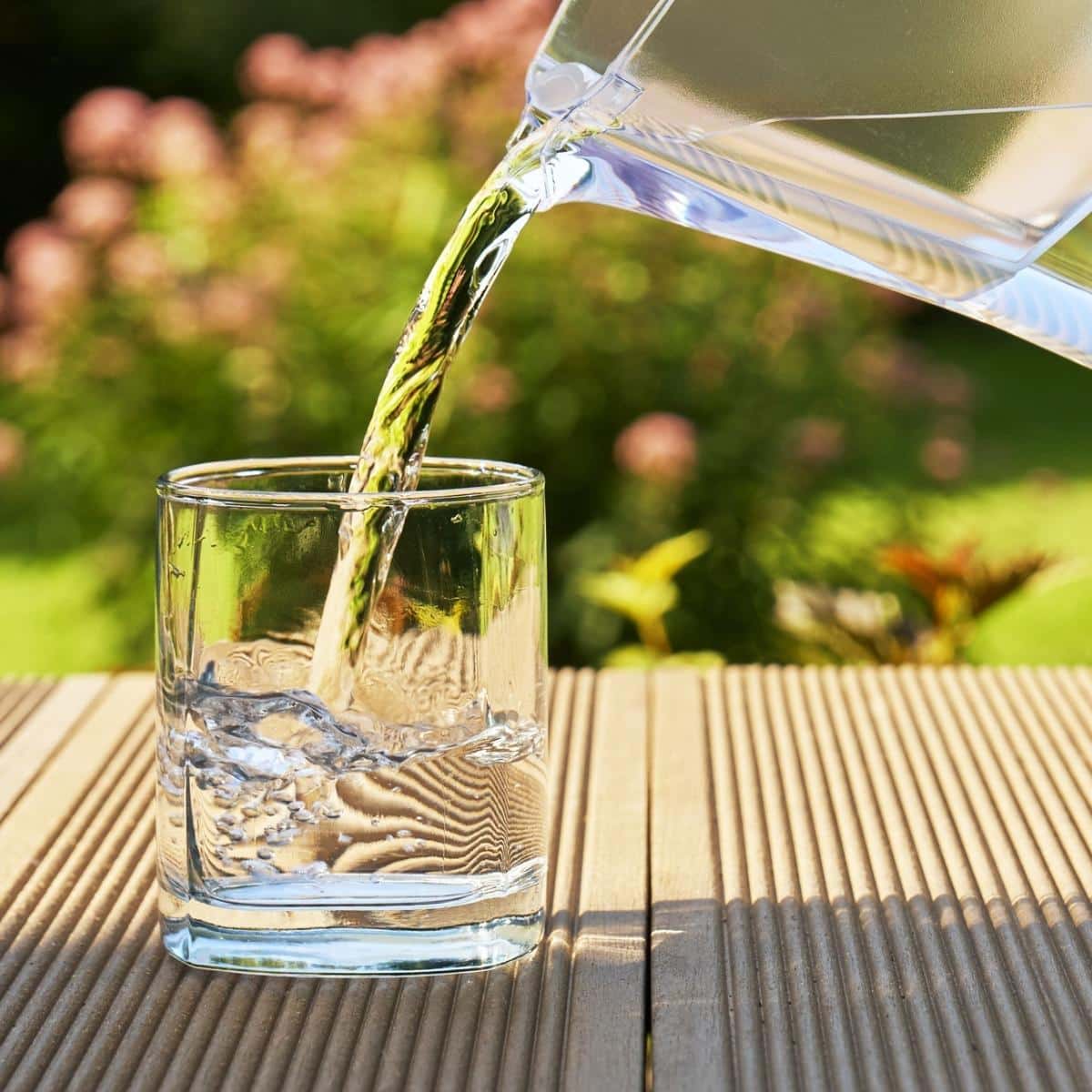 Pouring clear filtered water from a water filtration jug into a glass