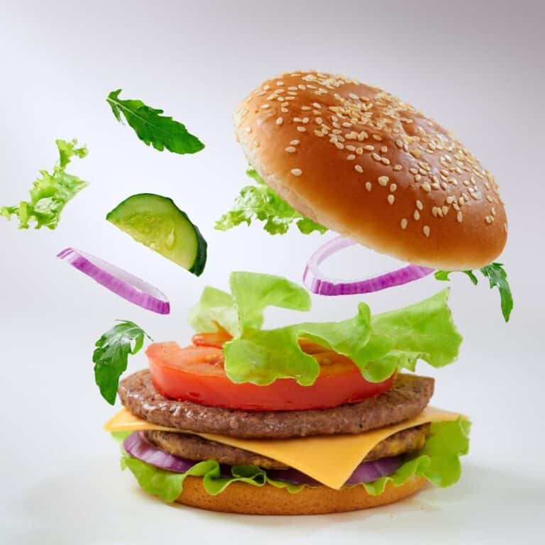 Big tasty burger with flying ingredients.