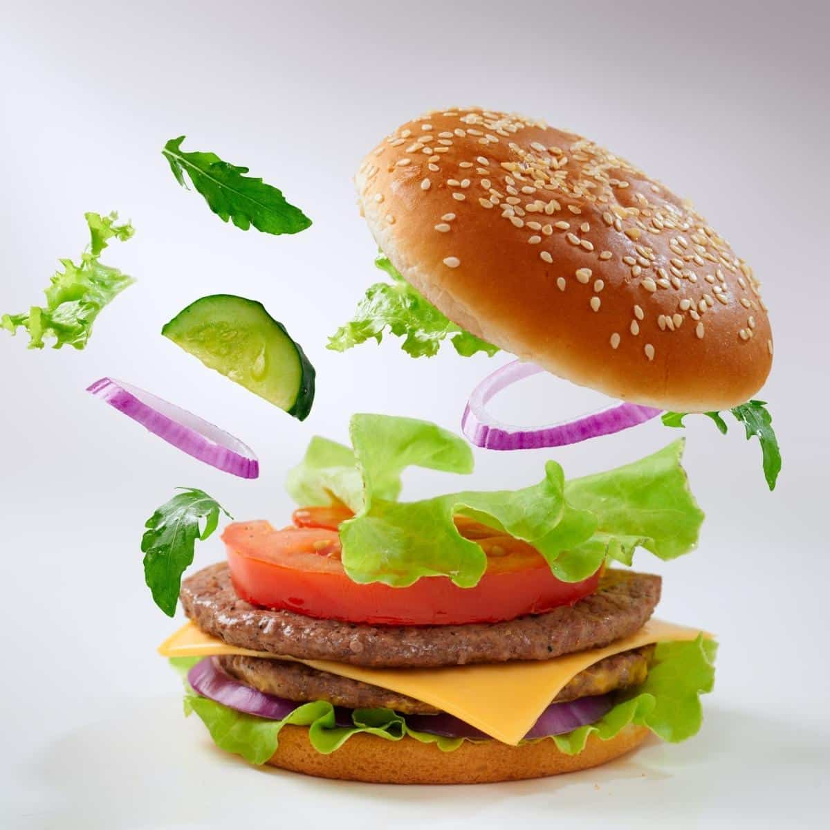  Big tasty burger with flying ingredients.