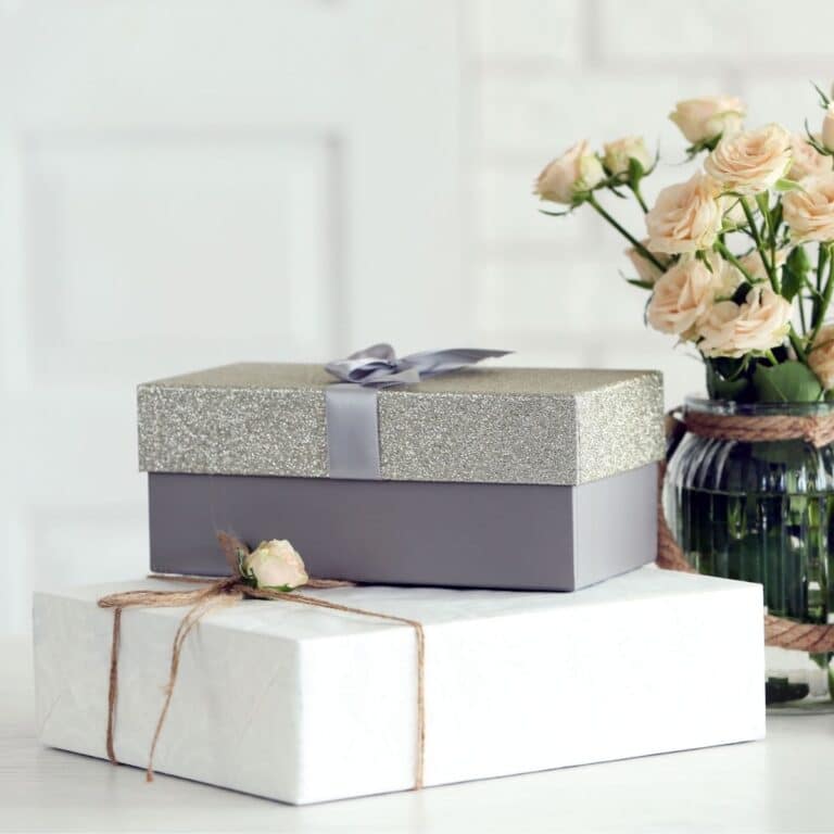 Beautiful gift boxes with bouquet of flowers on the table in front of brick wall