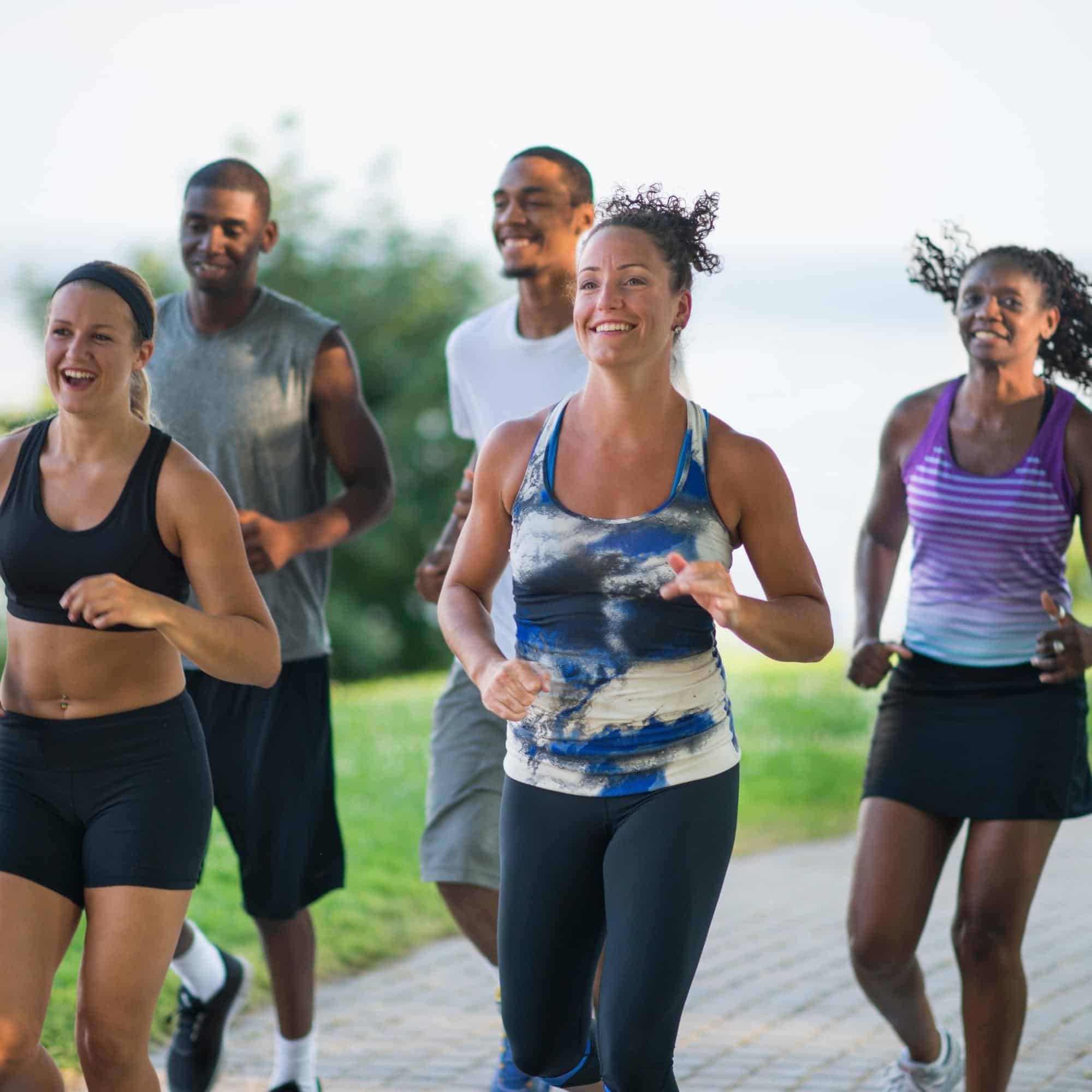 Diverse group of adults running outside