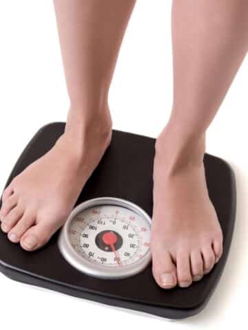 Woman feet standing on weigh scales