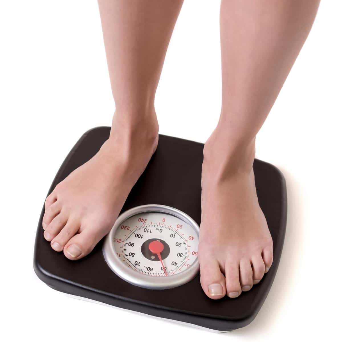 Woman feet standing on weigh scales