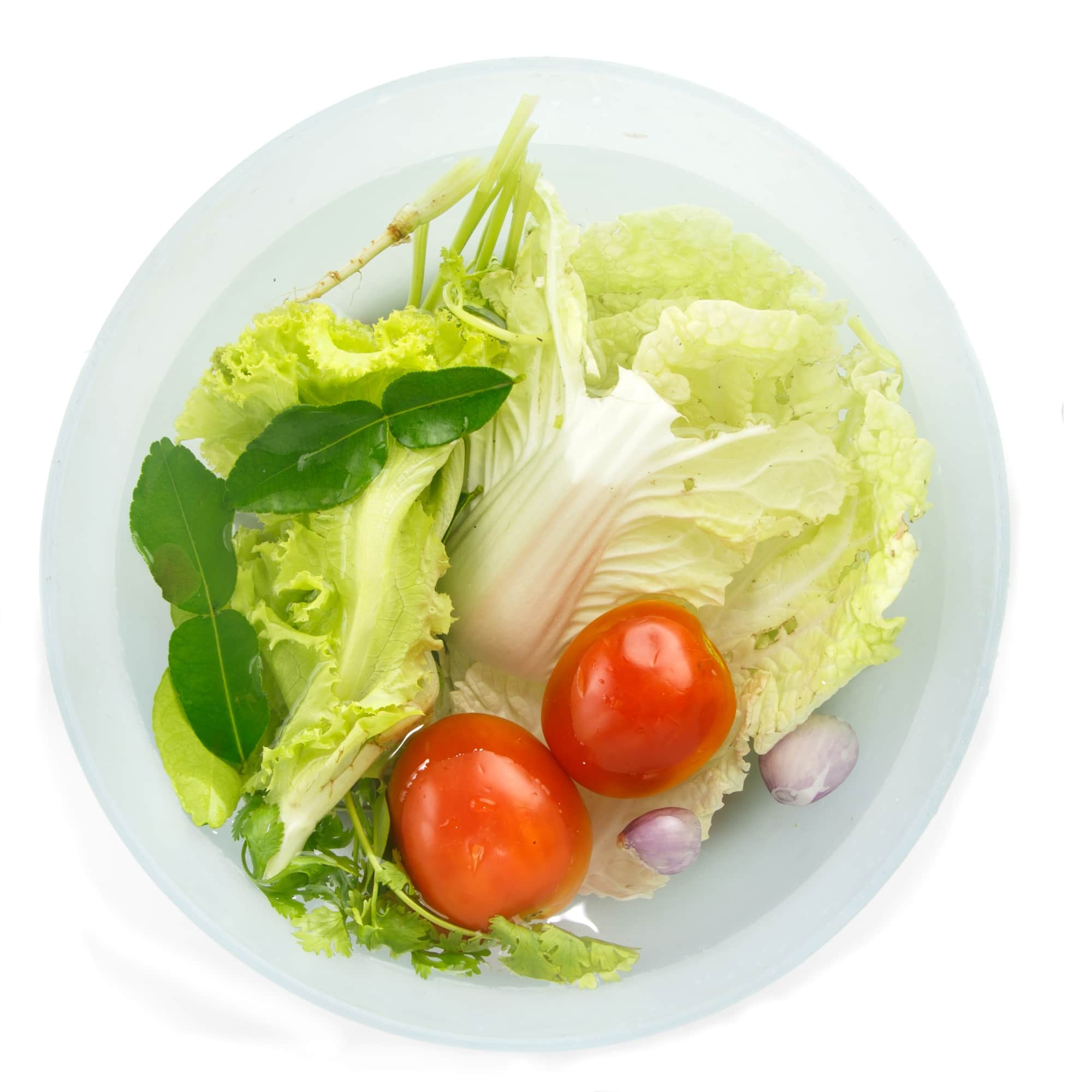 a bowl filled with lettuce and tomatoes soak in clean water