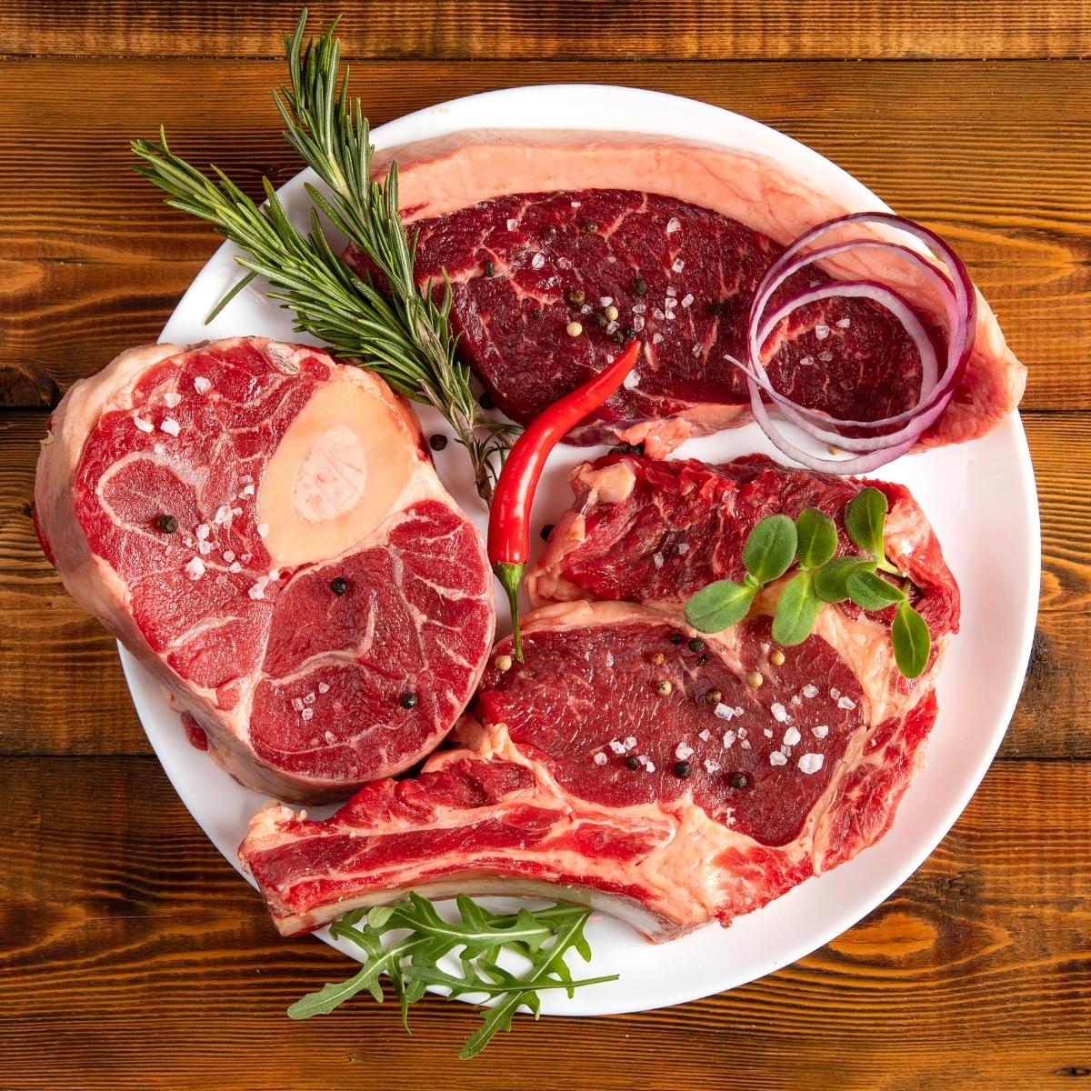 Chunks of raw meat on a white plate.