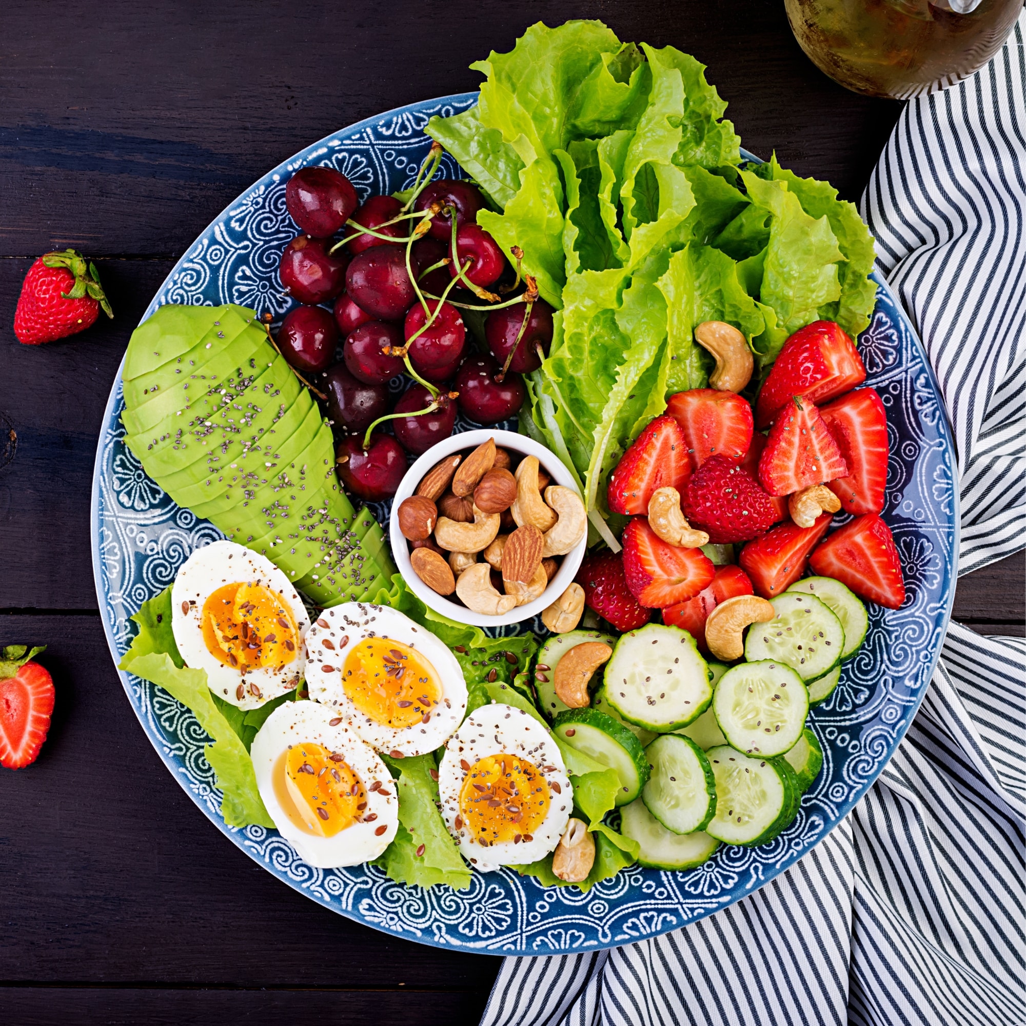 a plate filled with fruit and vegetables on a wooden table