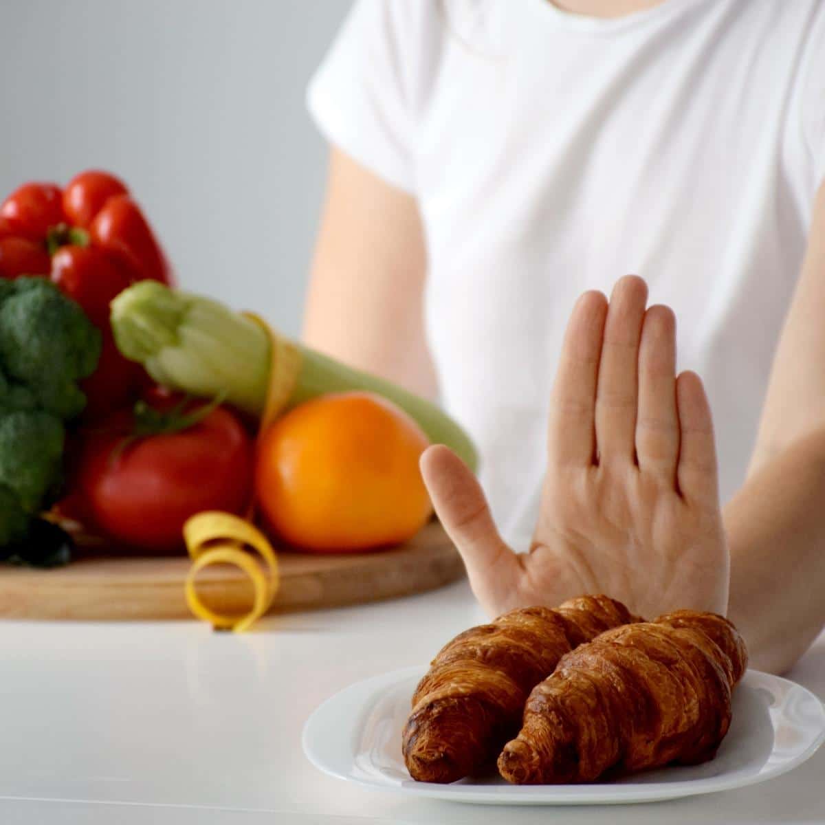 Hand of woman refusing from dessert in favor of vegetables