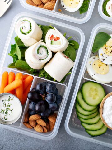 a bunch of food in plastic containers on a table