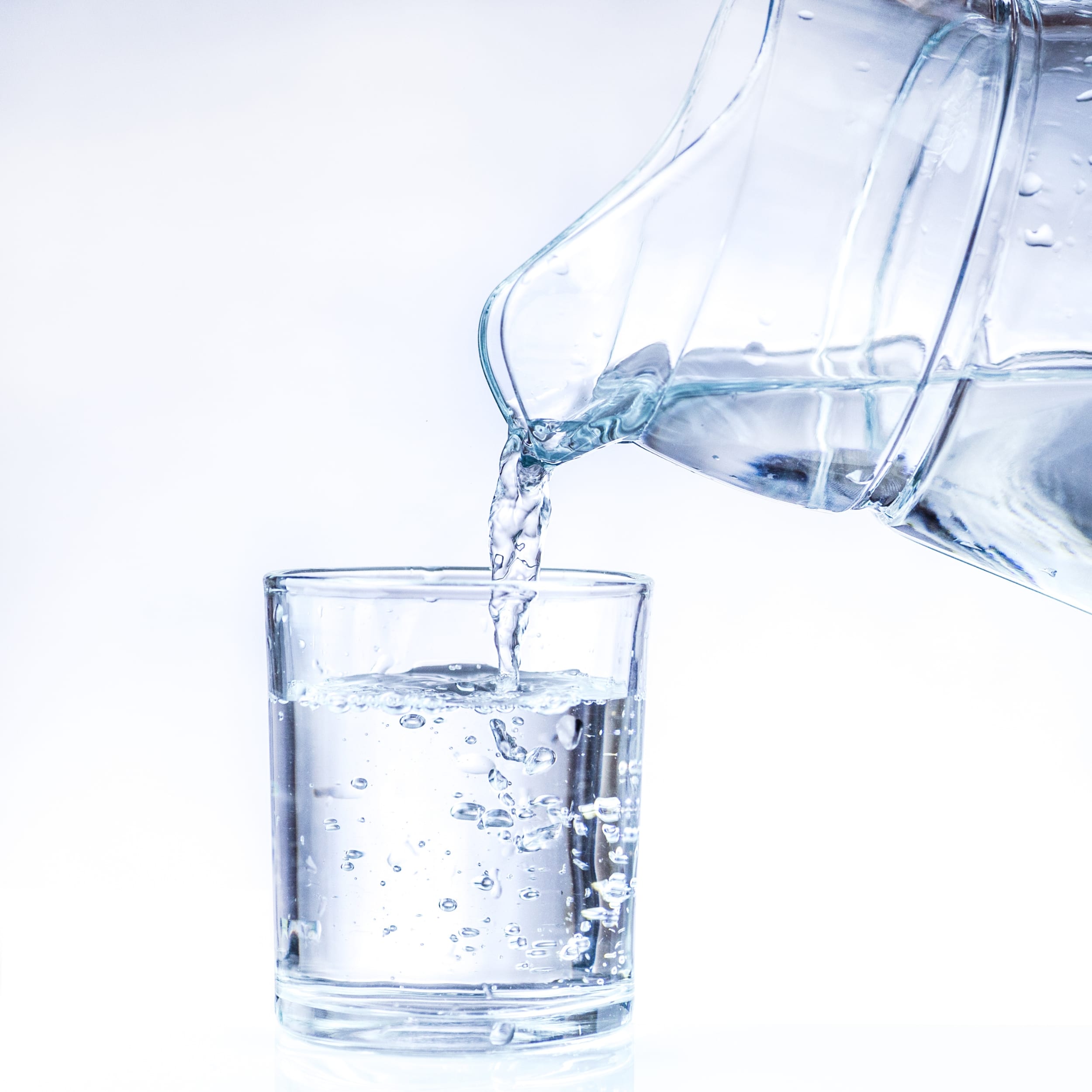 a glass of water being poured into a glass