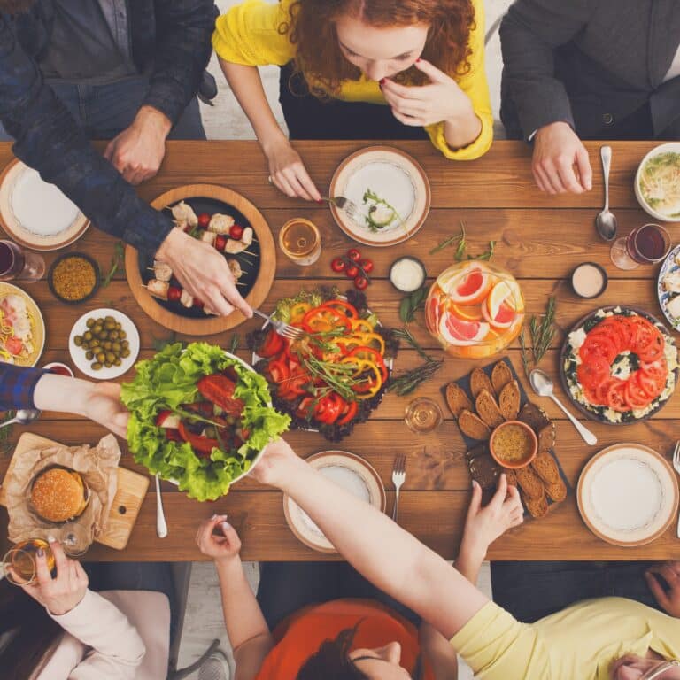 a group of people sitting around a table with food