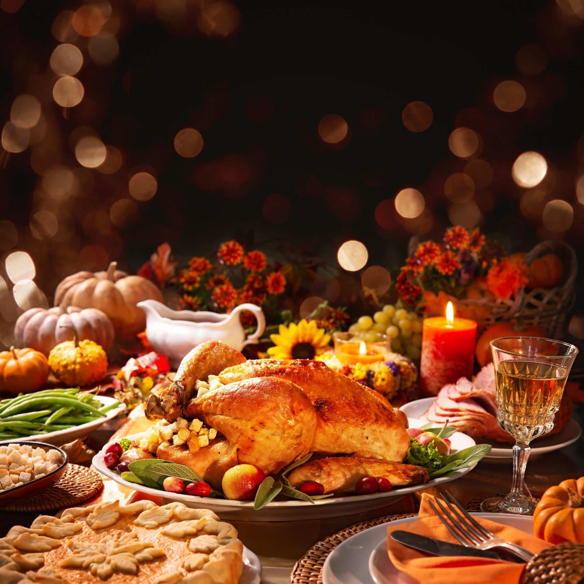 thanksgiving dinner with food on a wooden table with bokeh lights in the background