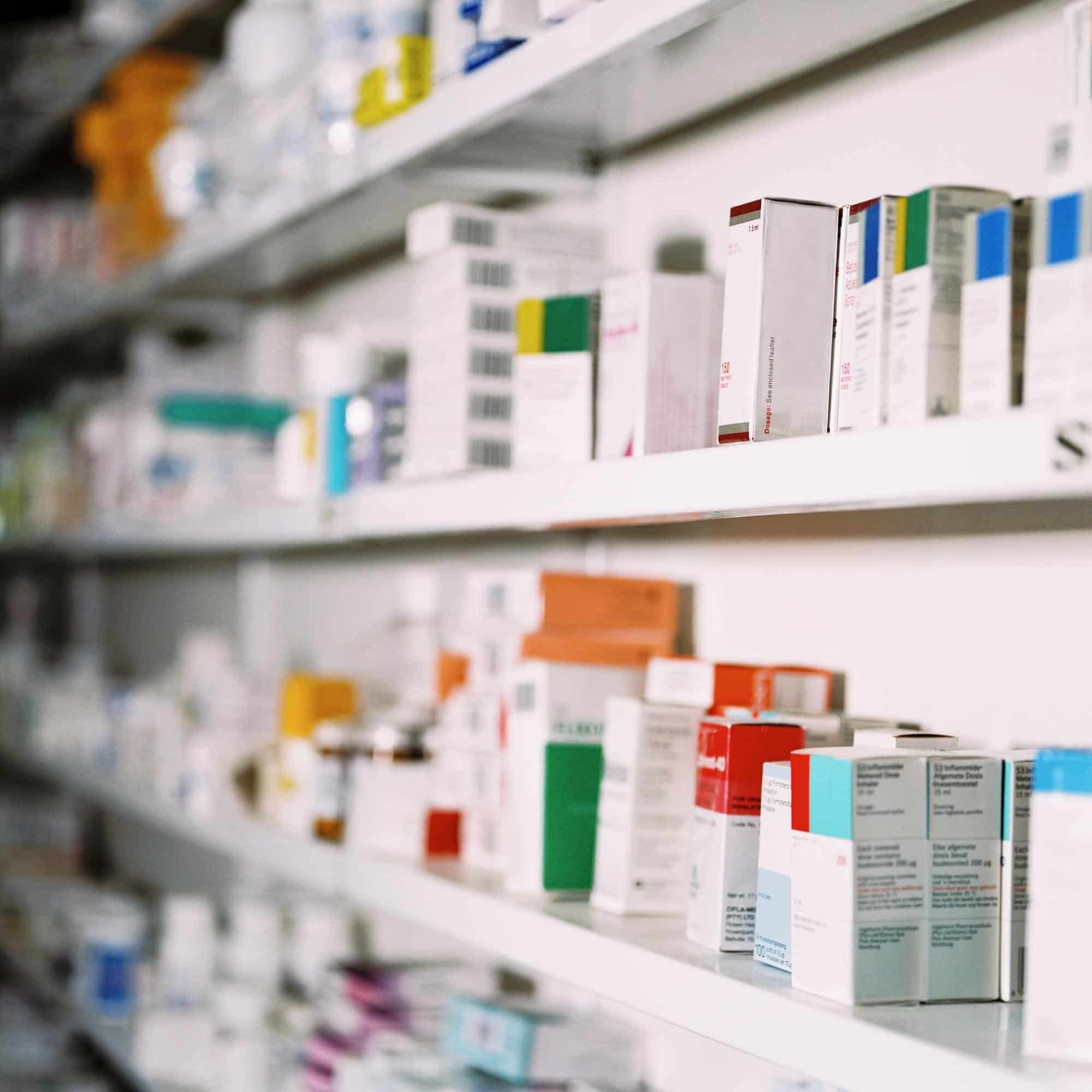 pharmaceutical products are displayed on shelves in a pharmacy