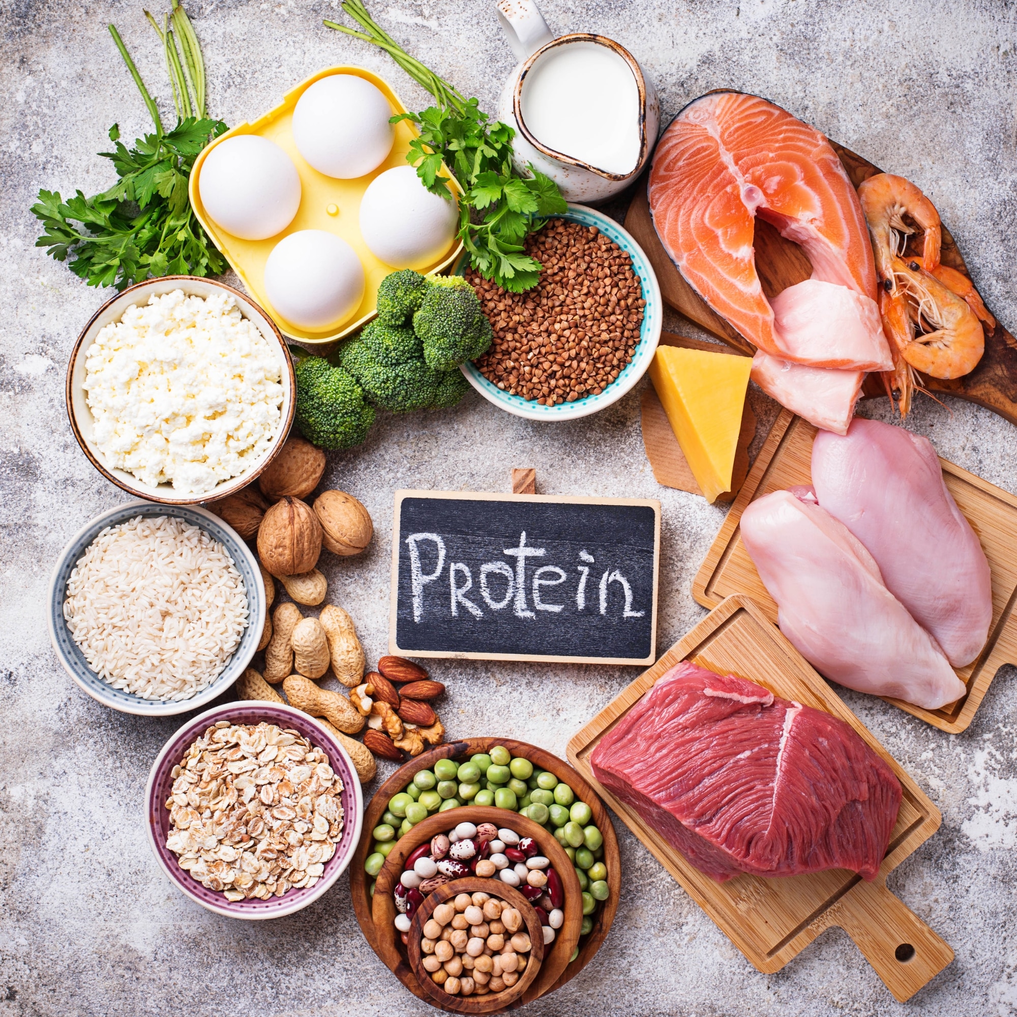 an assortment of foods with the word protein written on a chalkboard