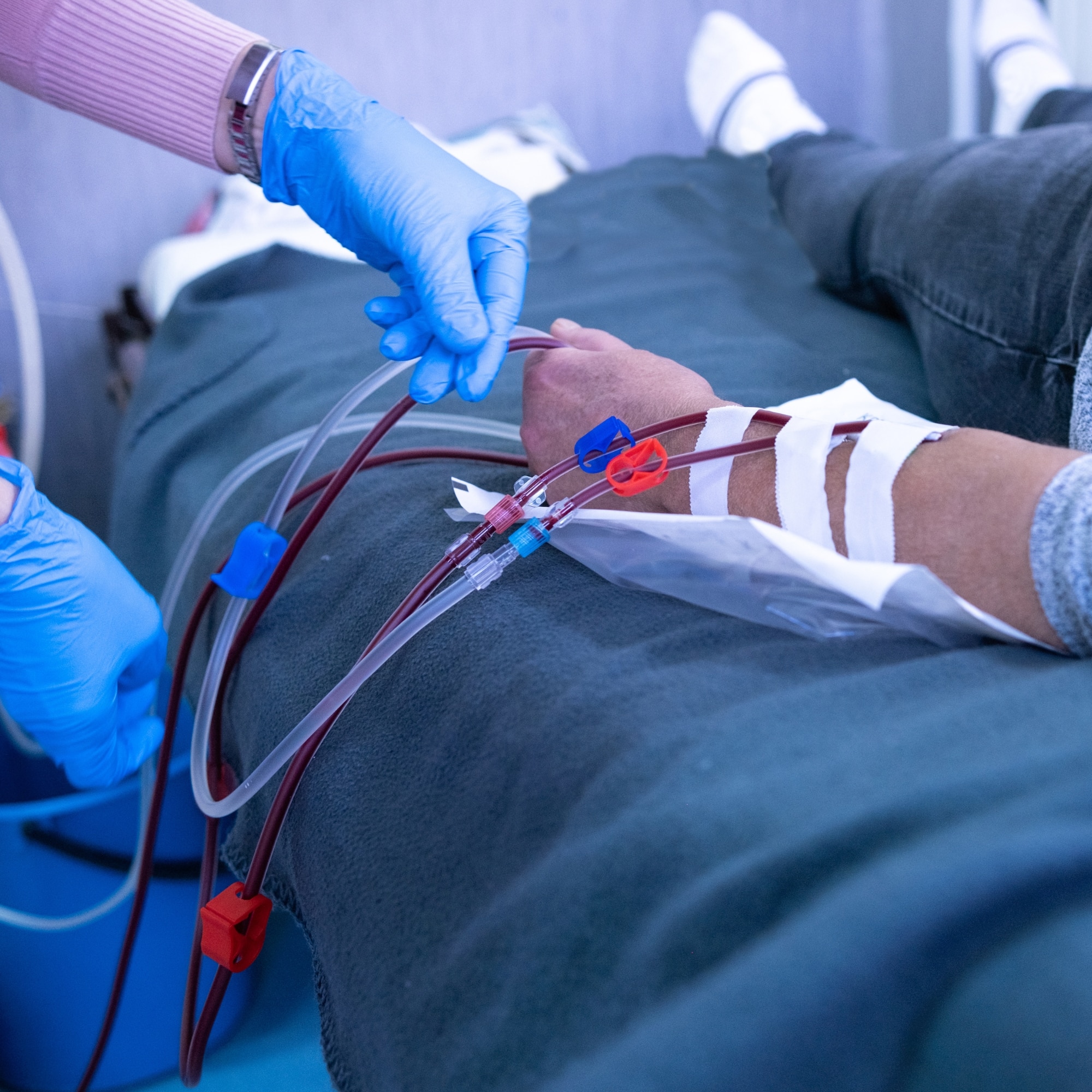 a person in a hospital bed receiving blood from an IV