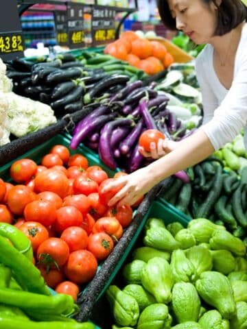 a person looking at vegetables in a grocery store