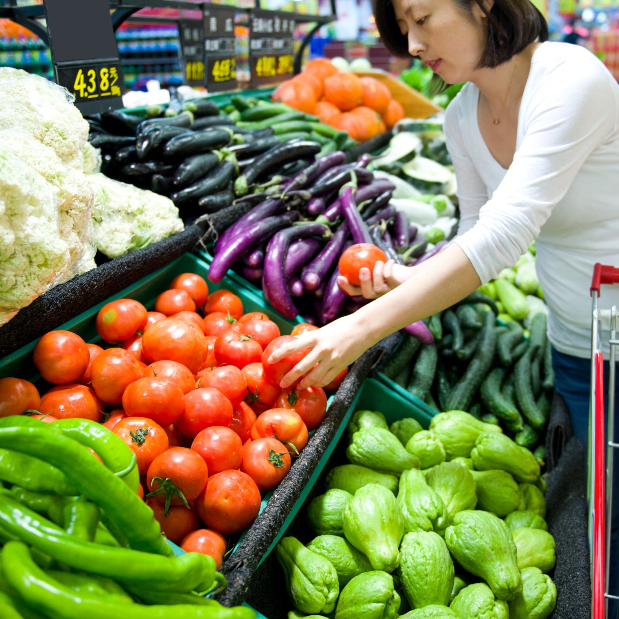 a person looking at vegetables in a grocery store