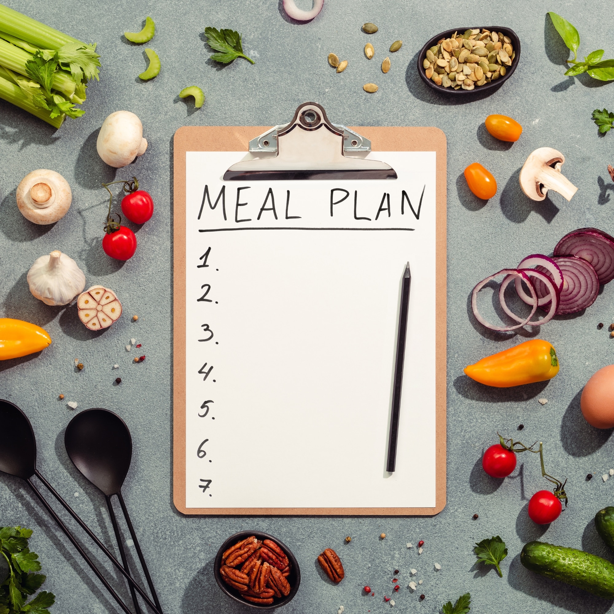 meal plan on clipboard surrounded by fresh vegetables and fruits