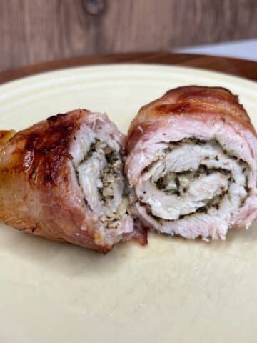 Baked bacon wrapped turkey breast tenderloin on a plate.