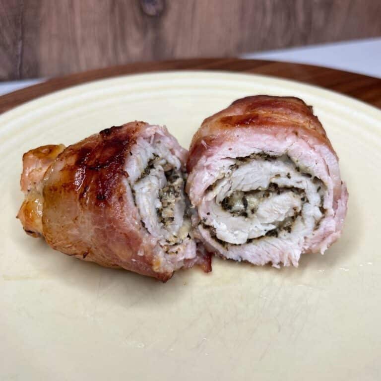 Baked bacon wrapped turkey breast tenderloin on a plate.