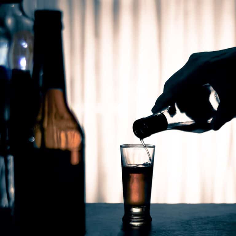 Person pouring alcohol in a glass