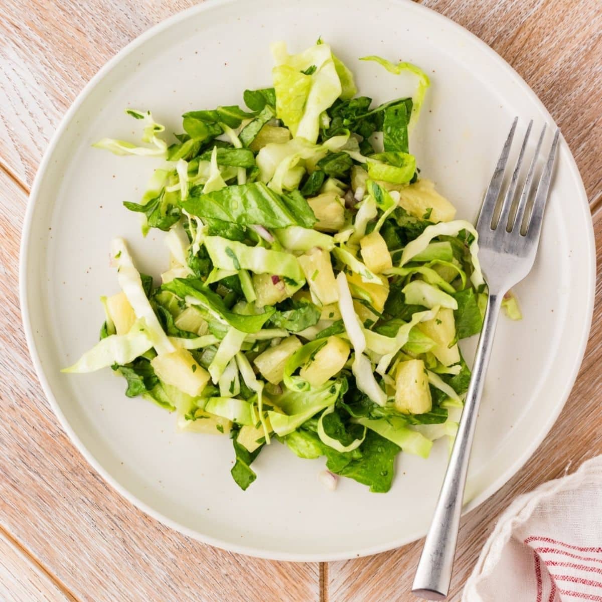 Pineapple salad on a plate overhead shot with fork on side