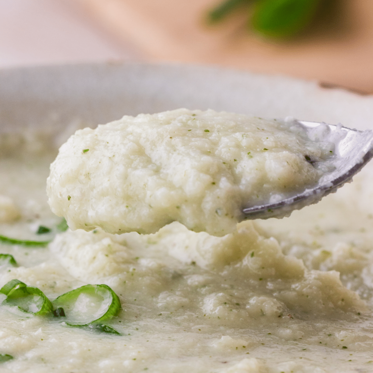 Close up of cauliflower goat cheese soup on a spoon.