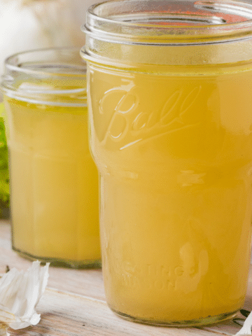 Two homemade vegetable broth servings in mason jars.
