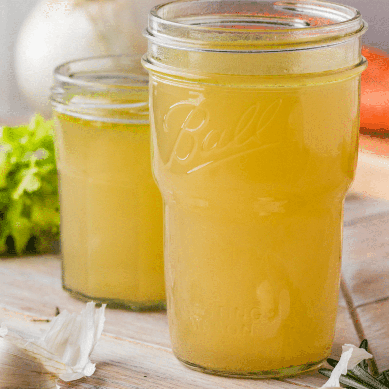 Two homemade vegetable broth servings in mason jars.