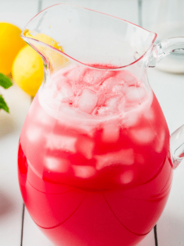 A pitcher of red Watermelon Mint Lemonade ready to be served to guests.