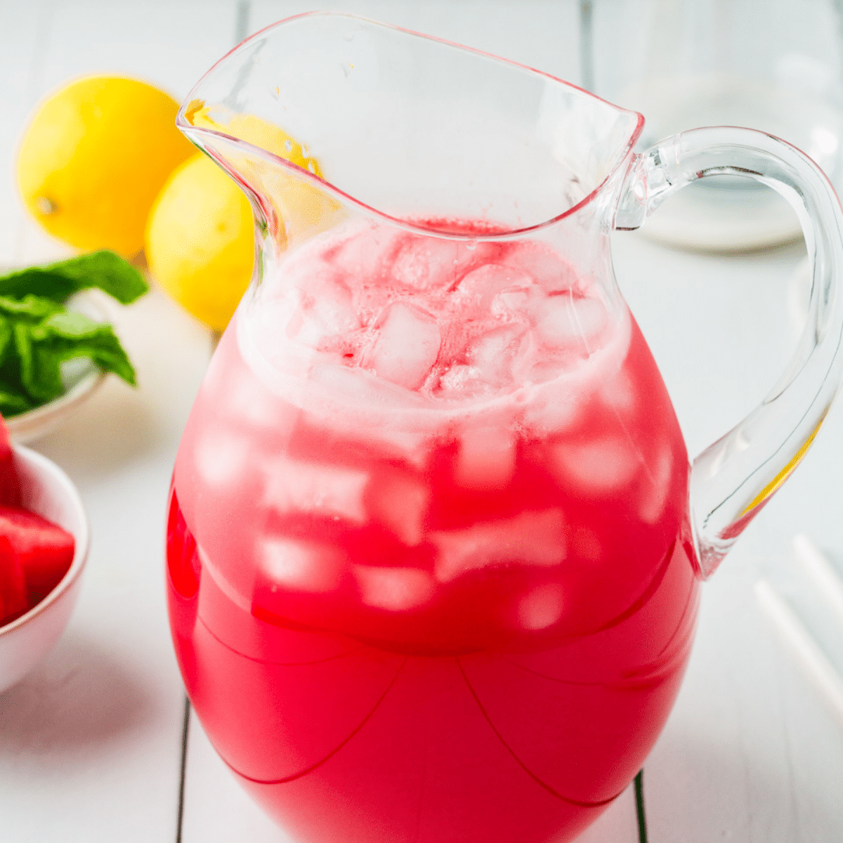 A pitcher of red Watermelon Mint Lemonade ready to be served to guests. 
