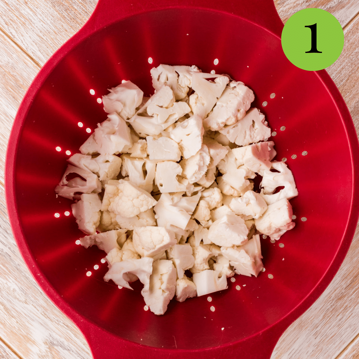 Cauliflower in a colander being cleaned to make soup. 
