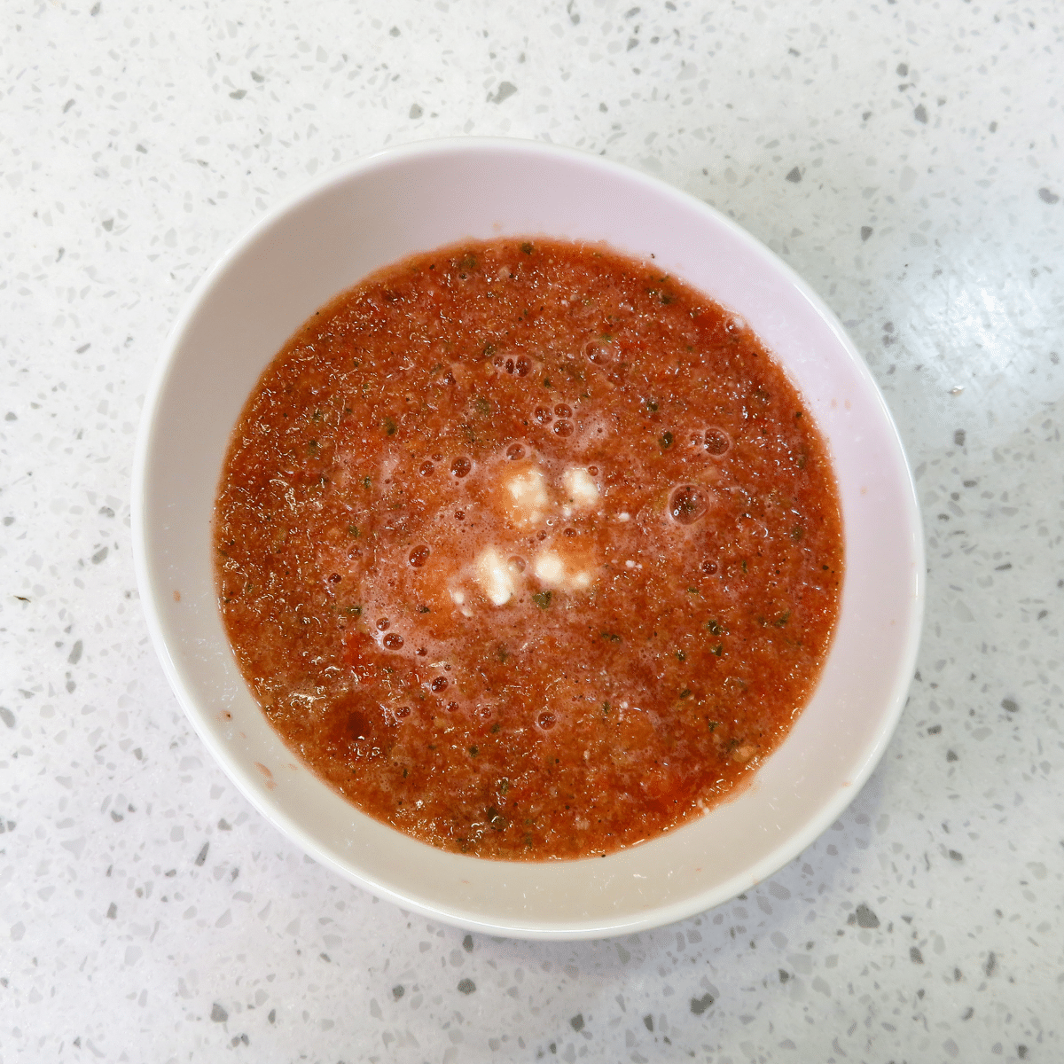 A white bowl of Watermelon Gazpacho, ready to be enjoyed by a person with Chronic Kidney Disease. 