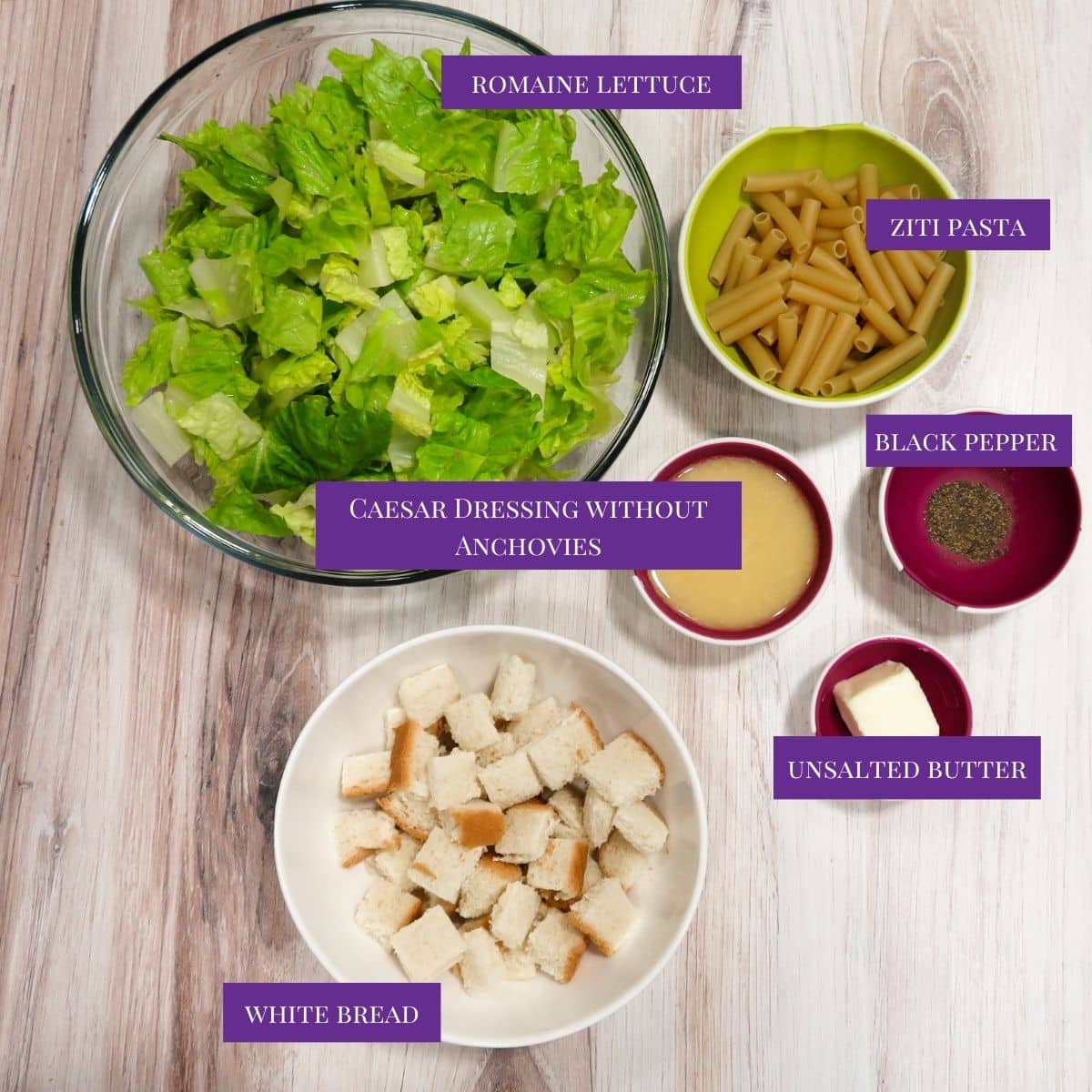 Ingredients for Caesar Pasta Salad laid out on a white counter. 