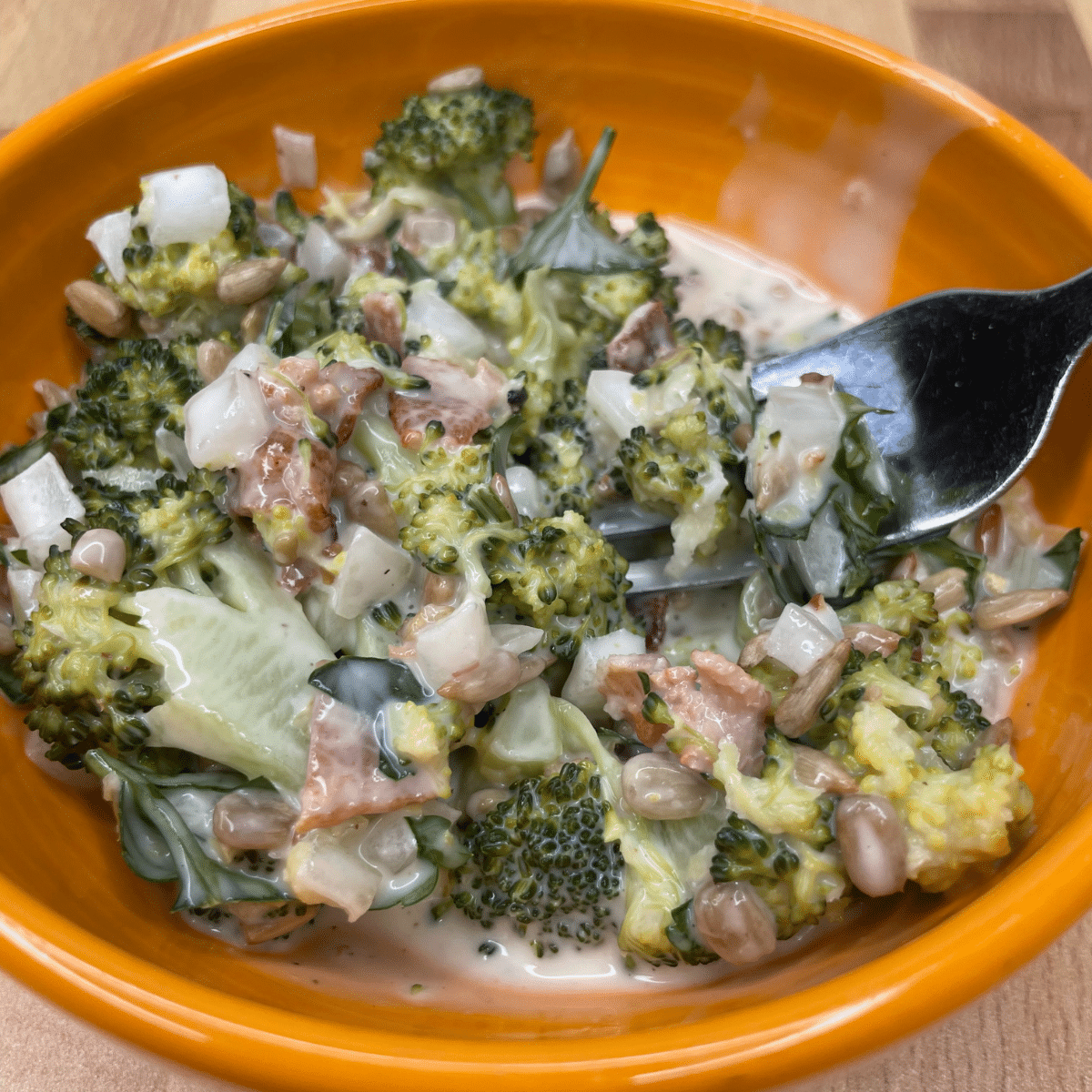 Creamy Broccoli Salad with Bacon on a fork ready to be served.