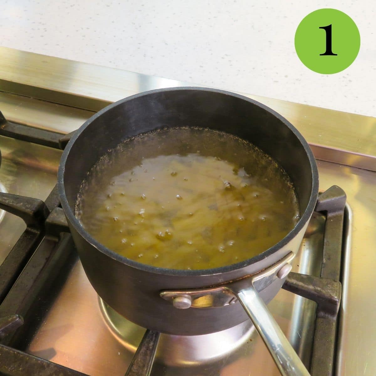 Pasta in a dark pan being boiled. 