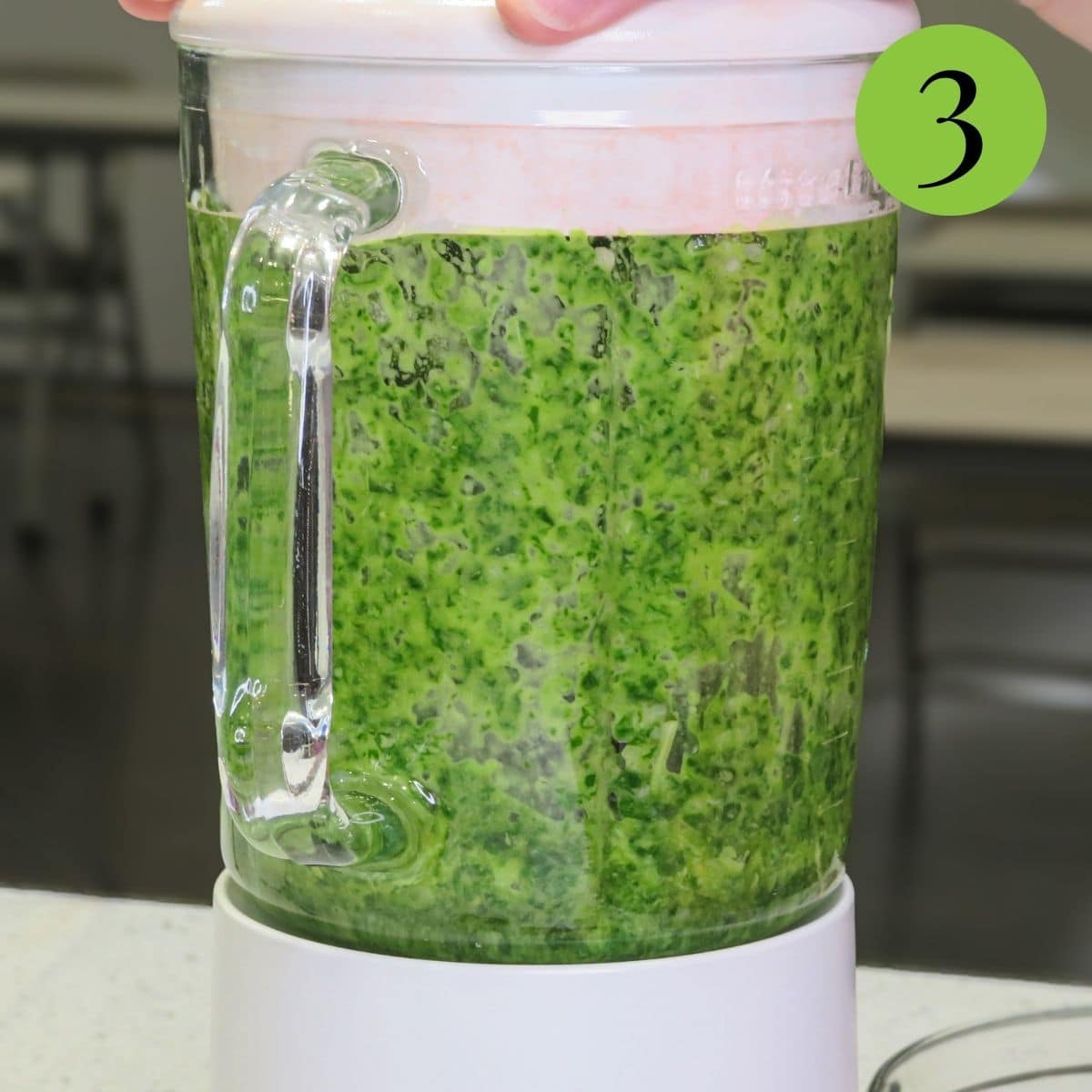 Basil pesto with lemon in a blender being blended up. 