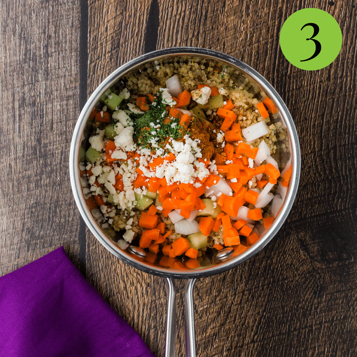 Cooked quinoa in a pan with carrots, onions, and feta cheese. 