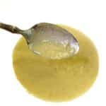 A silver spoon dipped in Caesar Dressing No Anchovies.
