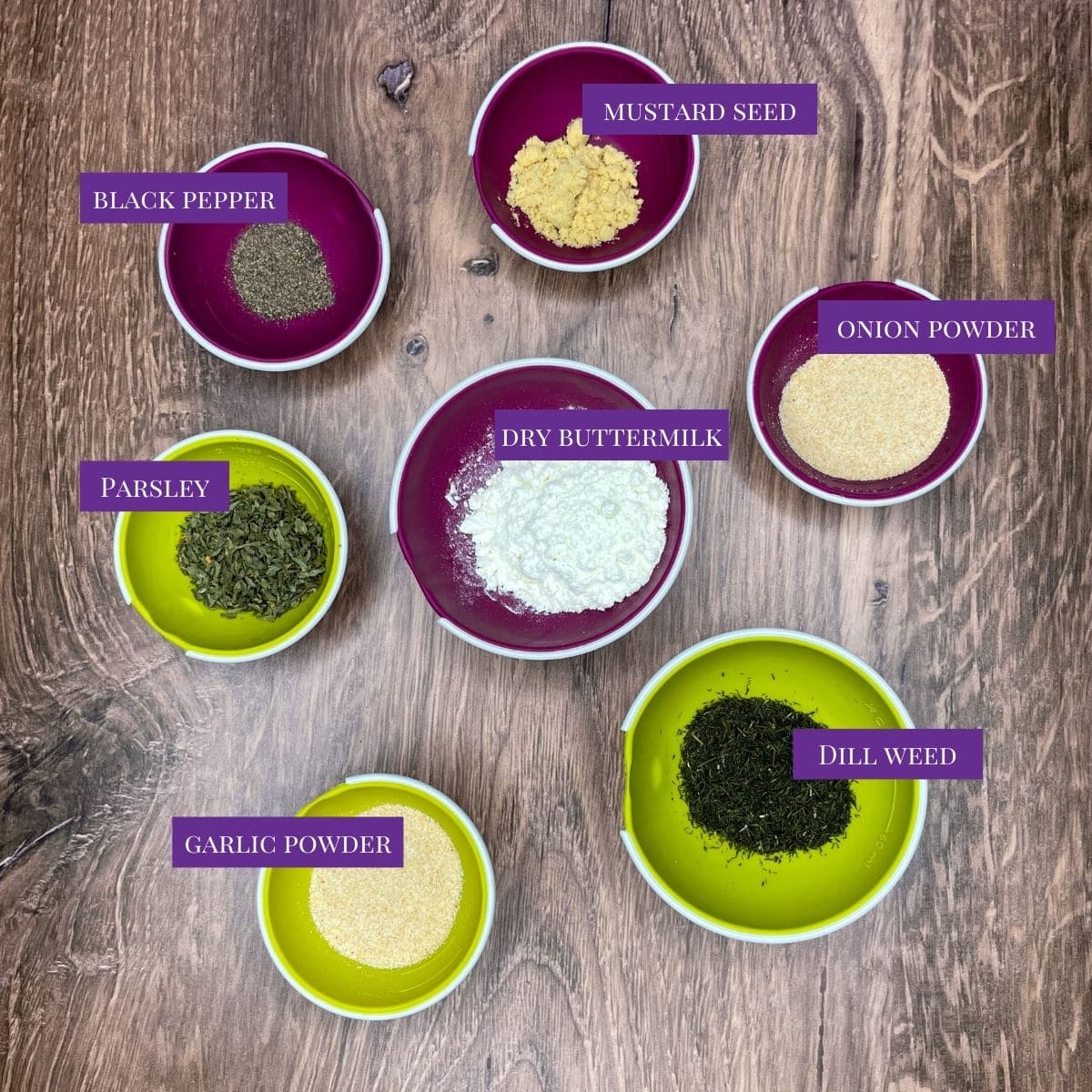 Mustard seed, onion powder, black pepper, dry buttermilk, dill weed, garlic powder, and parsley all laid out ready to make ranch seasoning. 