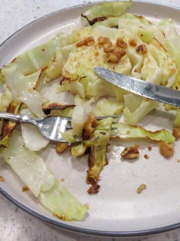 Close Up Of Roasted Cabbage Steaks in white plate.