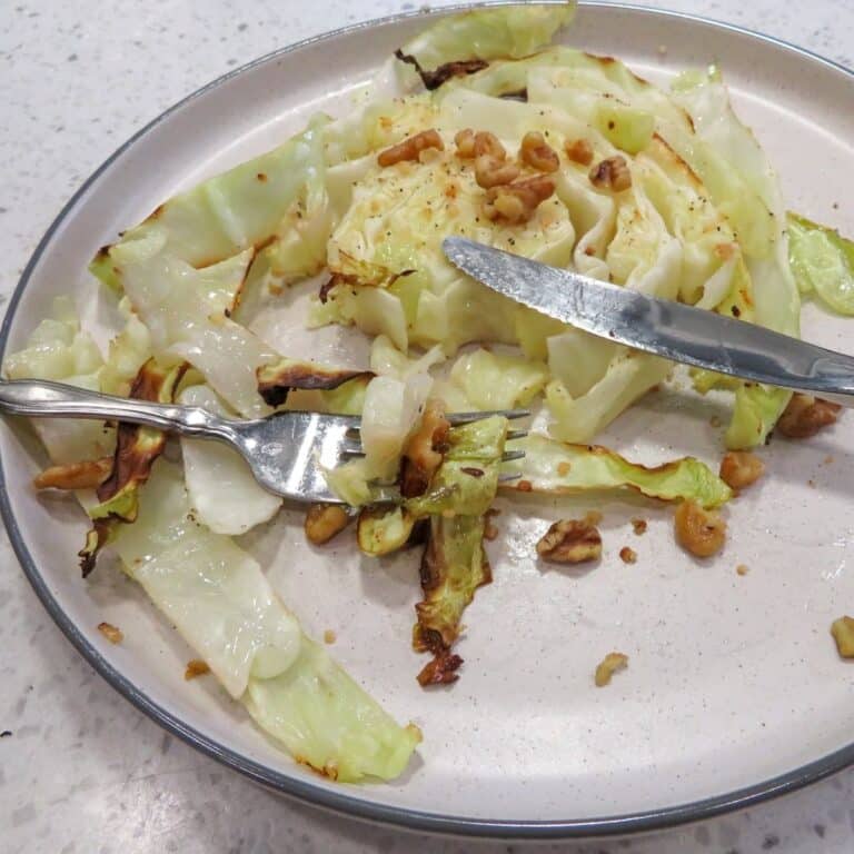 Close Up Of Roasted Cabbage Steaks in white plate.