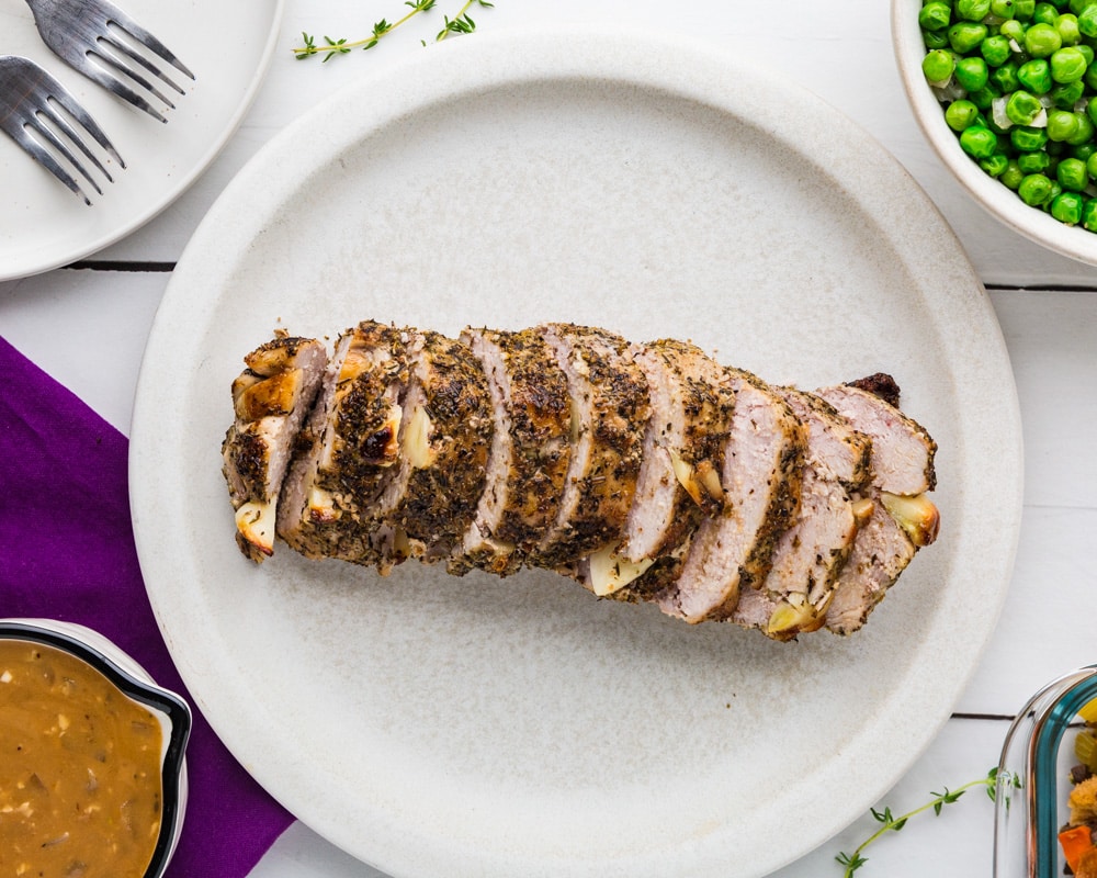 Boneless Pork Ribeye Roast with Pan Gravy on a plate with garlic