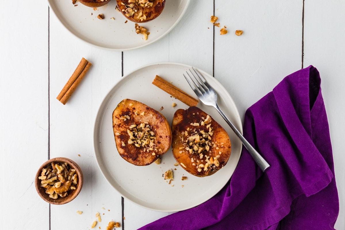 Cinnamon Baked Pears on a plate with walnuts